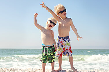 Children Cheering in the Sand at the Pediatric Dentist Serving Stamford and Greenwich